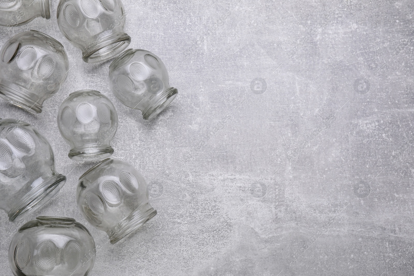 Photo of Glass cups on grey table, flat lay with space for text. Cupping therapy