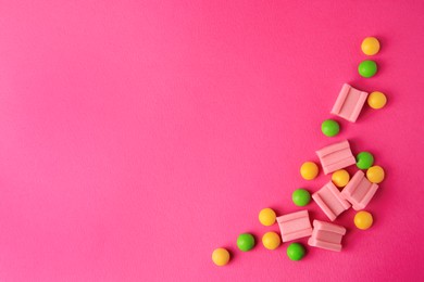 Many different chewing gums on pink background, flat lay. Space for text