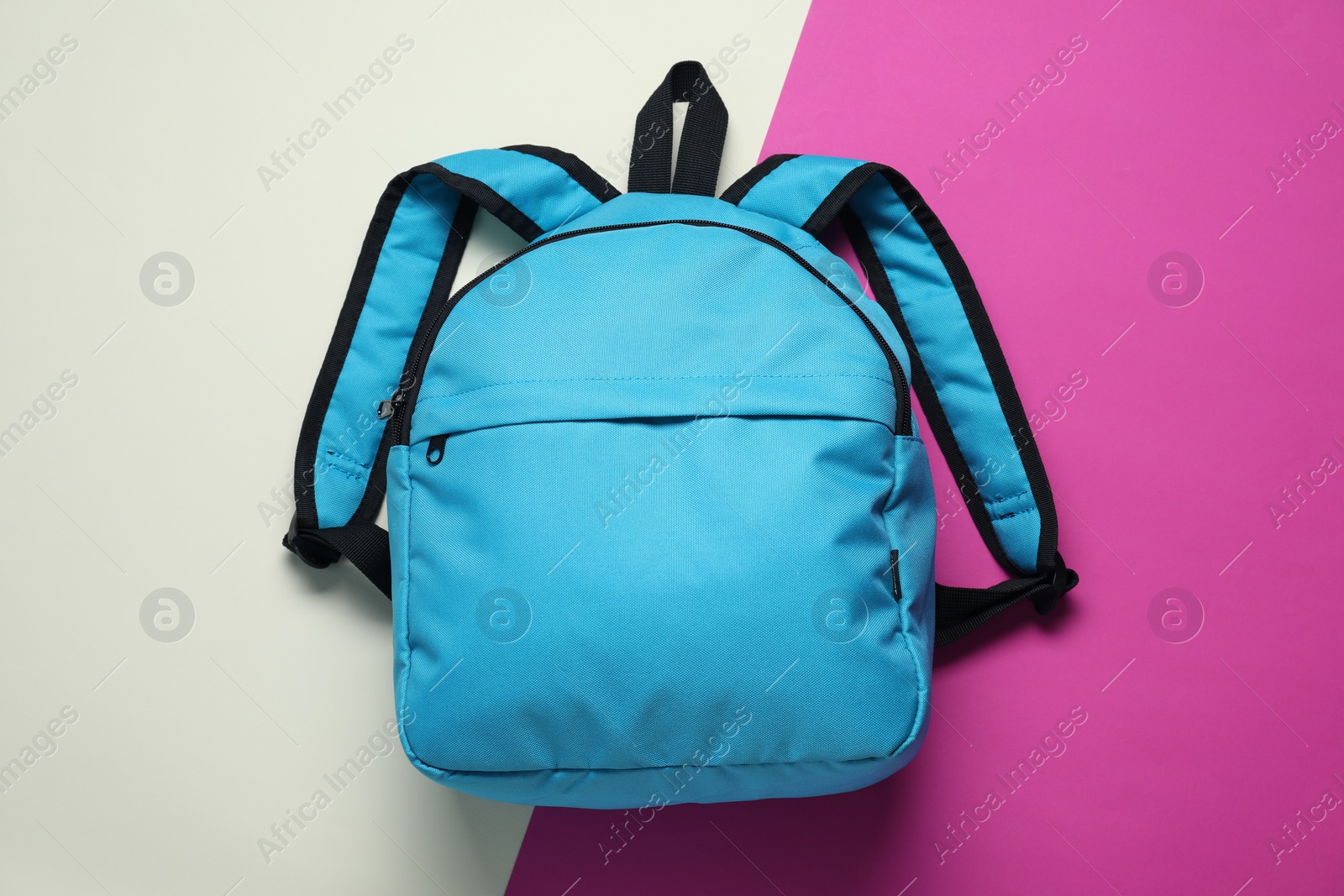 Photo of Stylish light blue backpack on color background, top view