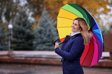 Woman with umbrella in autumn park on rainy day