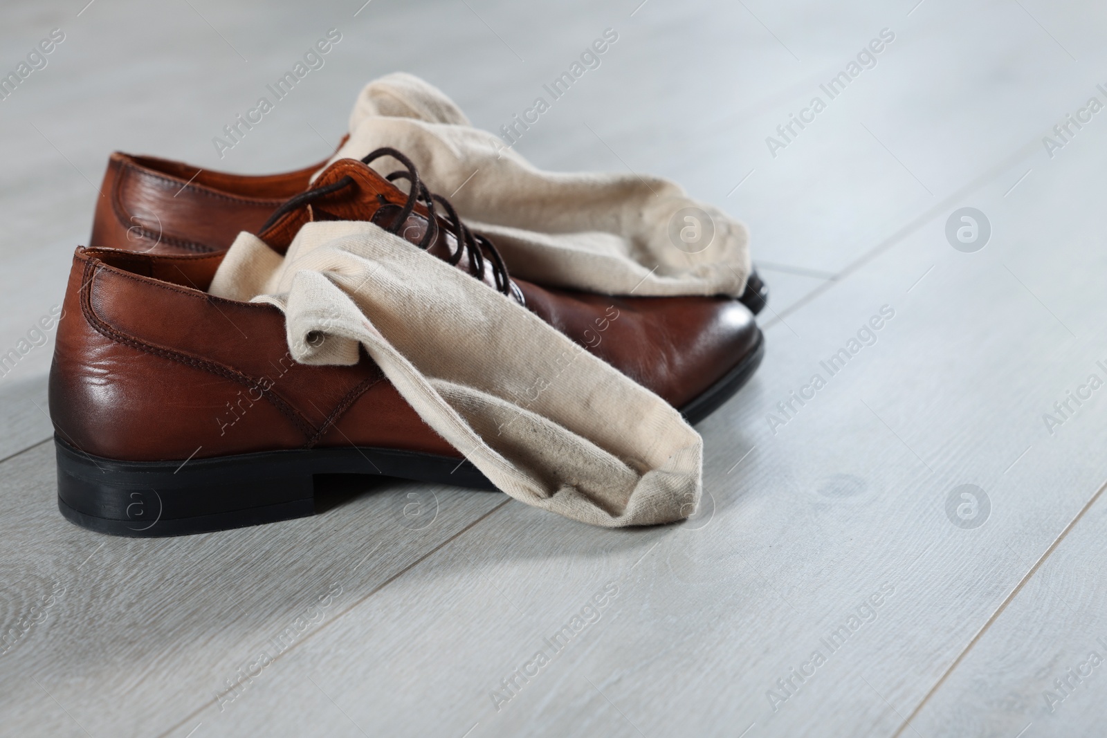 Photo of Stylish shoes with dirty socks on white wooden floor indoors, space for text