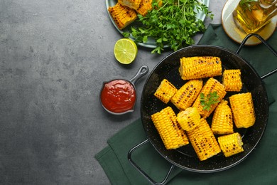 Photo of Flat lay composition with tasty corn and ingredients on dark grey table. Space for text