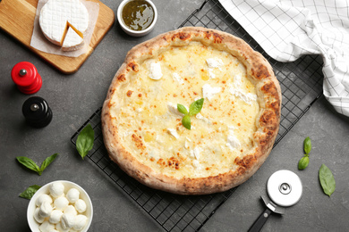 Delicious cheese pizza and fresh ingredients on grey table, flat lay