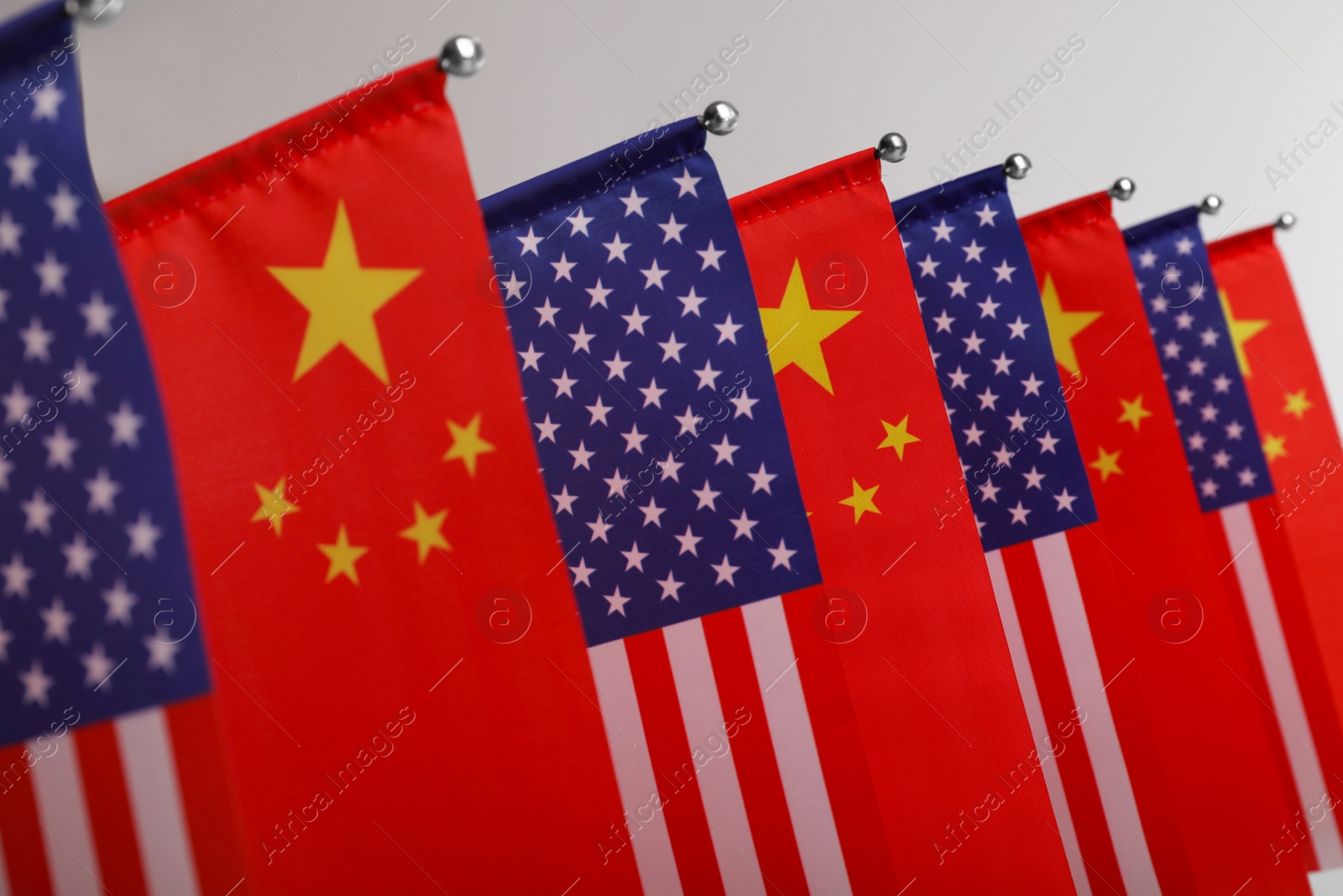 Photo of USA and China flags on light background, closeup. International relations