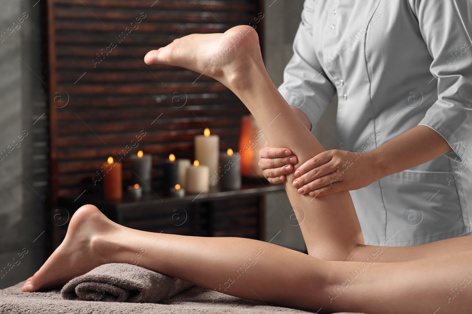Photo of Woman receiving leg massage in spa salon, closeup