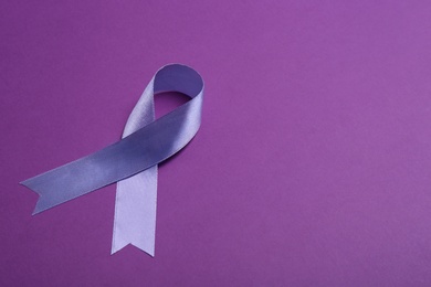 Purple awareness ribbon on color background, space for text