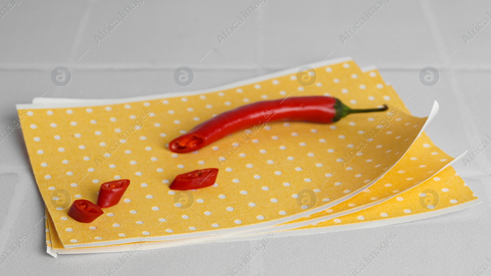 Photo of Pepper plaster and chili on white tiled table, closeup