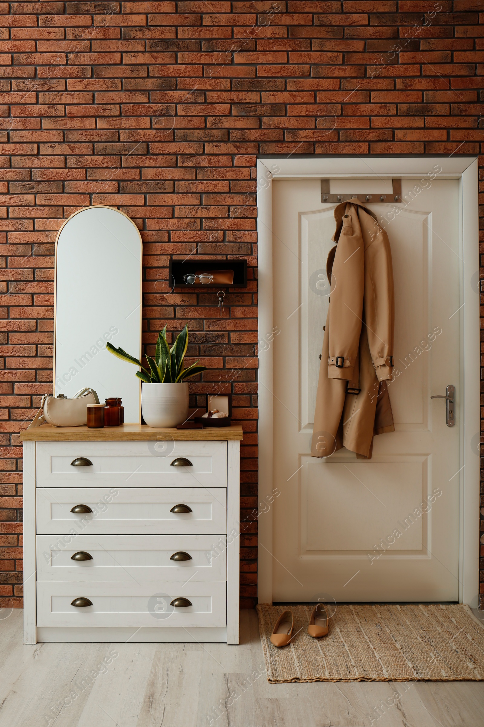 Photo of Stylish hanger for keys on brick wall in hallway