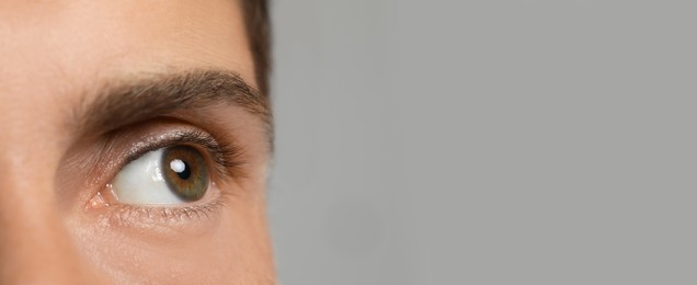 Image of Closeup view of man with beautiful eyes on light grey background, space for text. Banner design