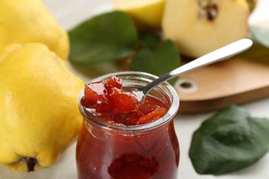 Photo of Delicious quince jam on light grey table, closeup