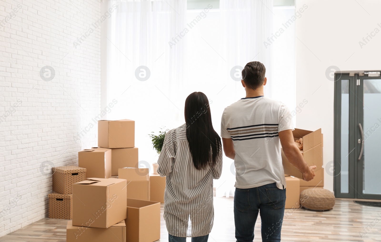 Photo of Couple in room with cardboard boxes on moving day