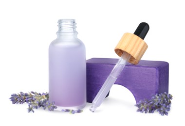 Bottle of lavender essential oil and flowers on white background