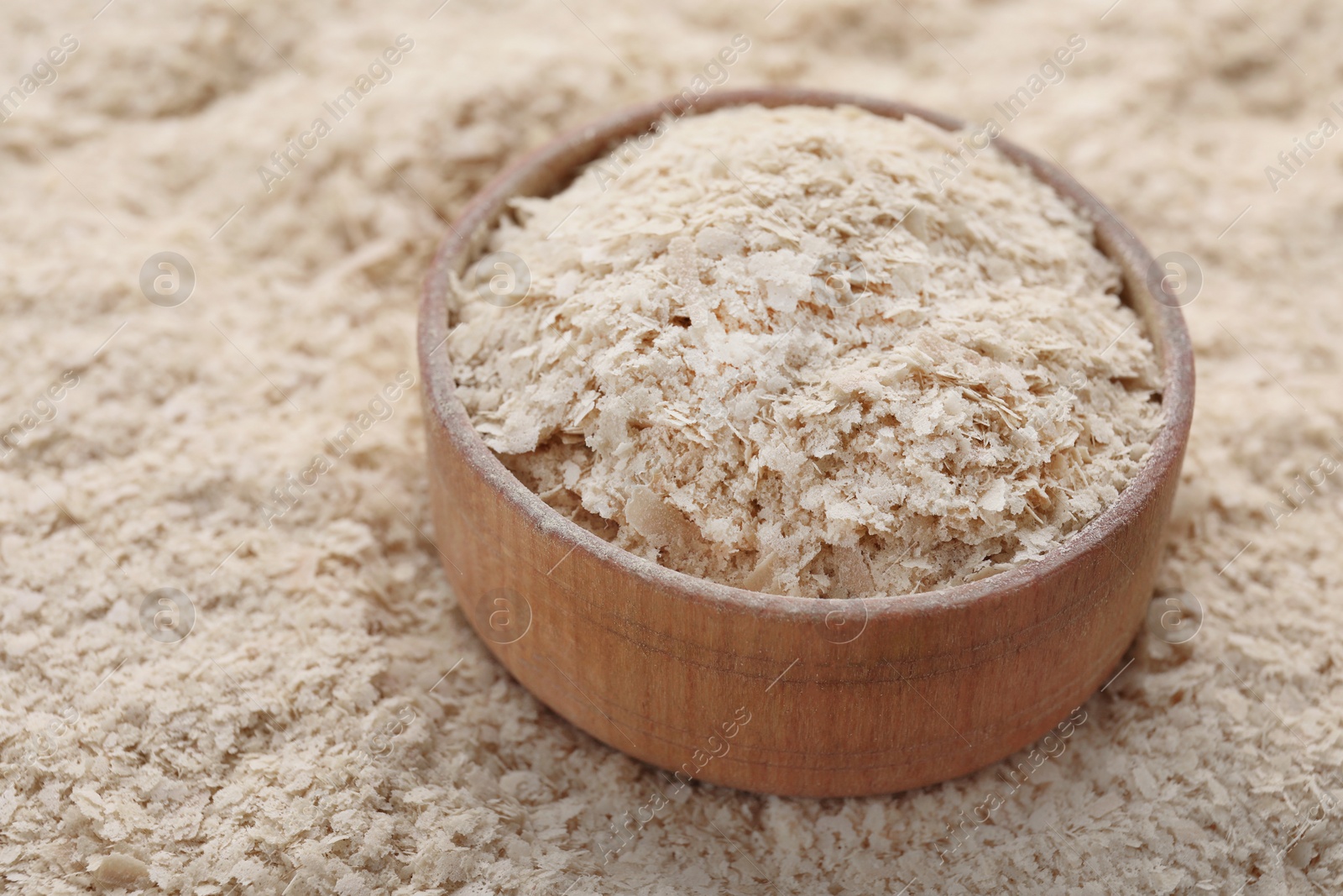 Photo of Wooden bowl of brewer`s yeast on flakes, closeup