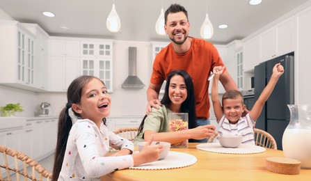Image of Happy family with children having fun during breakfast at home