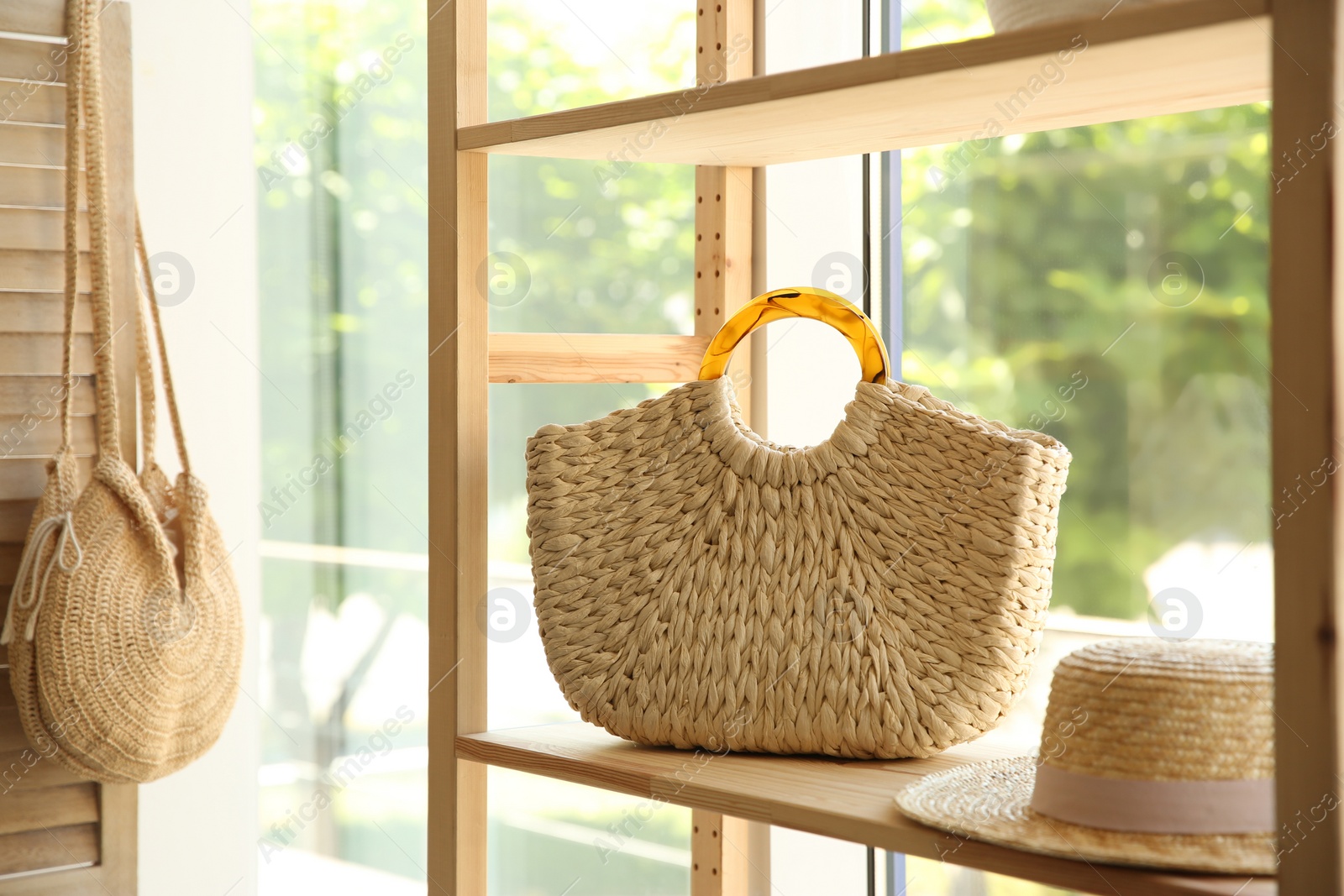 Photo of Stylish knitted woman's bag on shelf in boutique