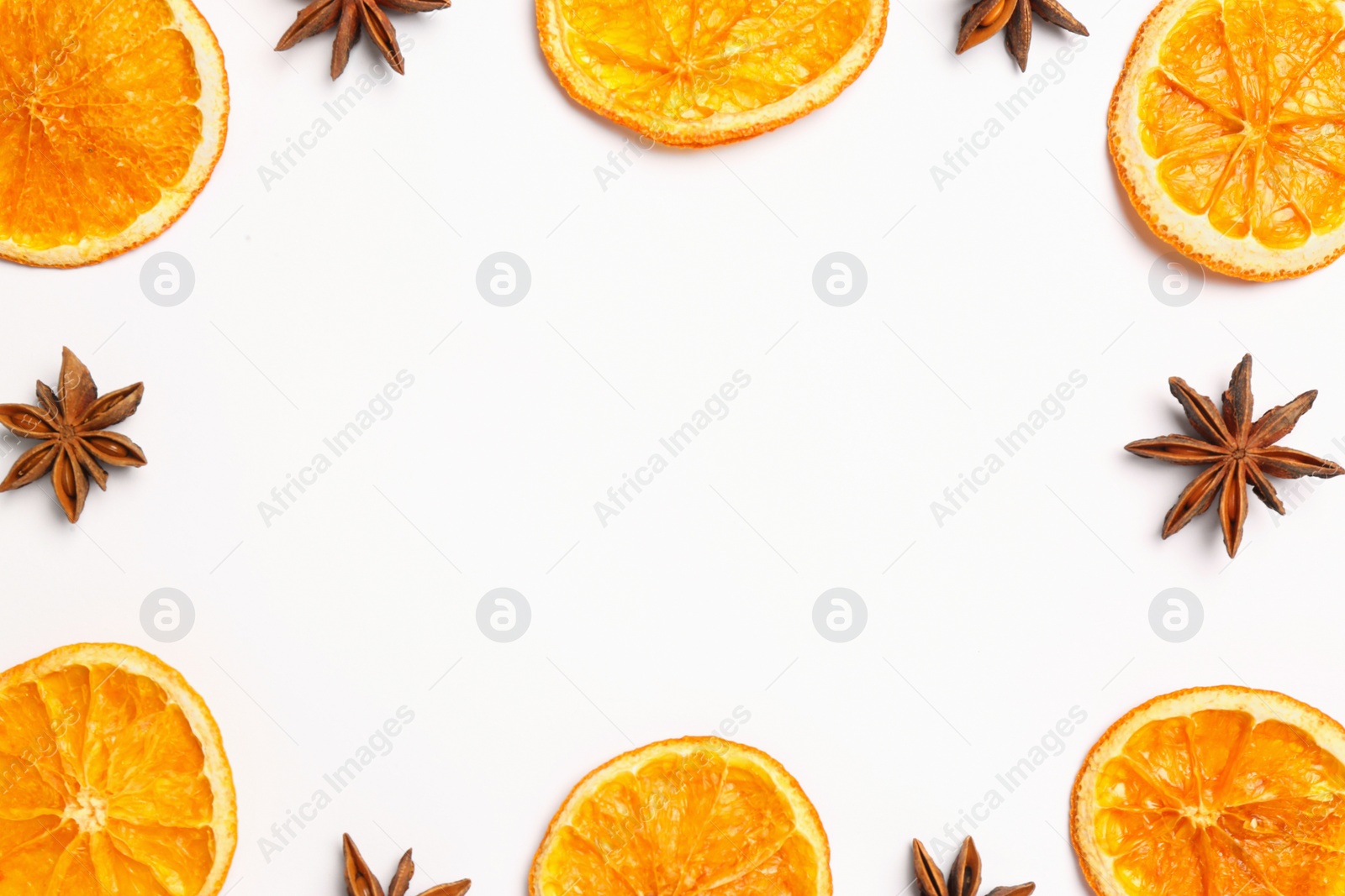 Photo of Frame made of dry orange slices and anise stars on white background, flat lay with space for text