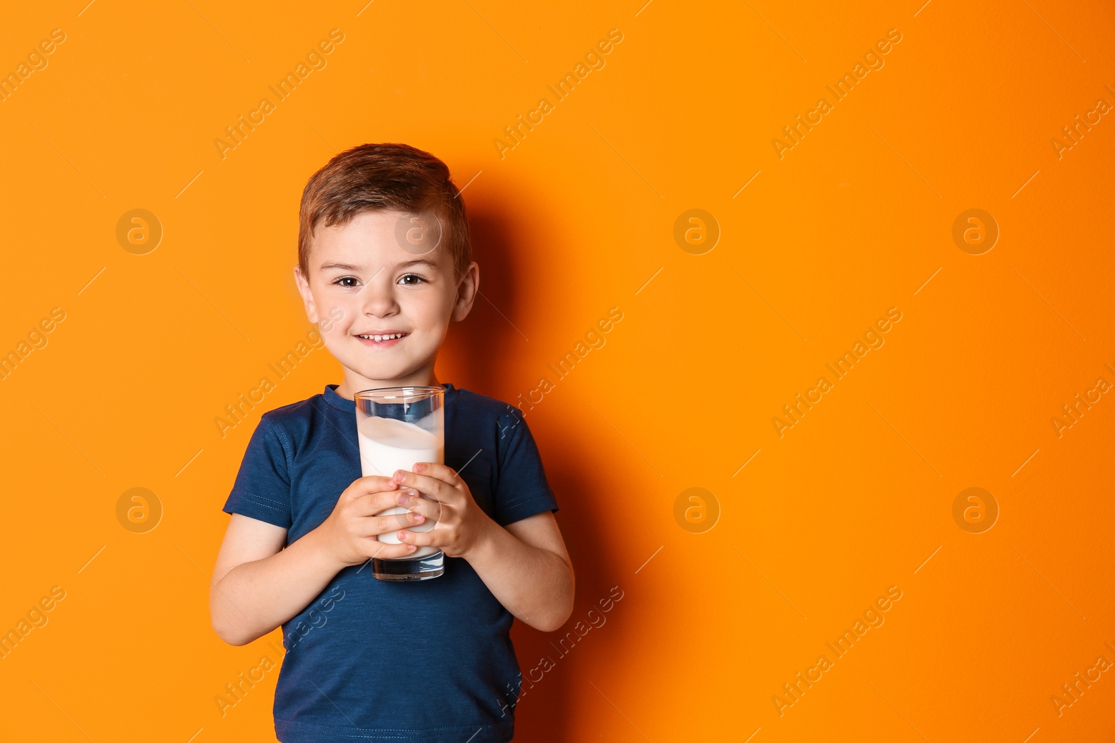 Photo of Cute little boy with glass of milk on color background