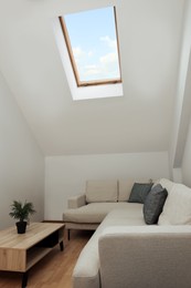 Photo of Attic room interior with slanted ceiling and furniture