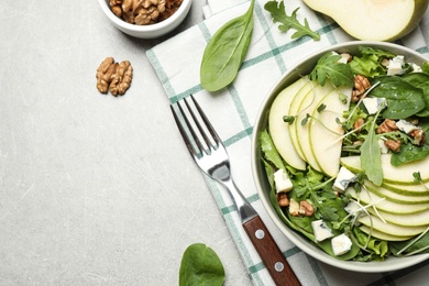 Photo of Tasty salad with pear slices served on light grey table, flat lay. Space for text