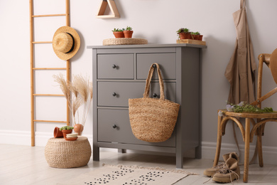 Grey chest of drawers in stylish room interior