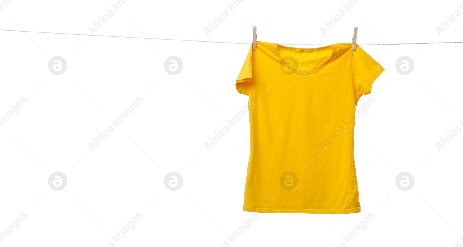 Photo of Yellow t-shirt drying on washing line against white background