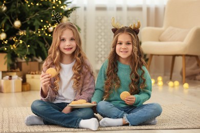 Photo of Cute little girls with cookies at home. Christmas atmosphere