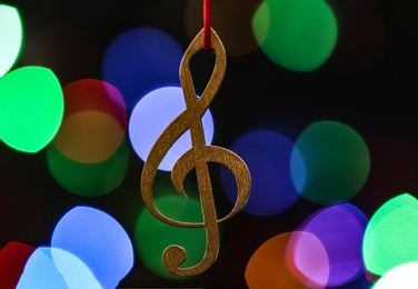 Photo of Wooden treble clef against blurred lights. Christmas music