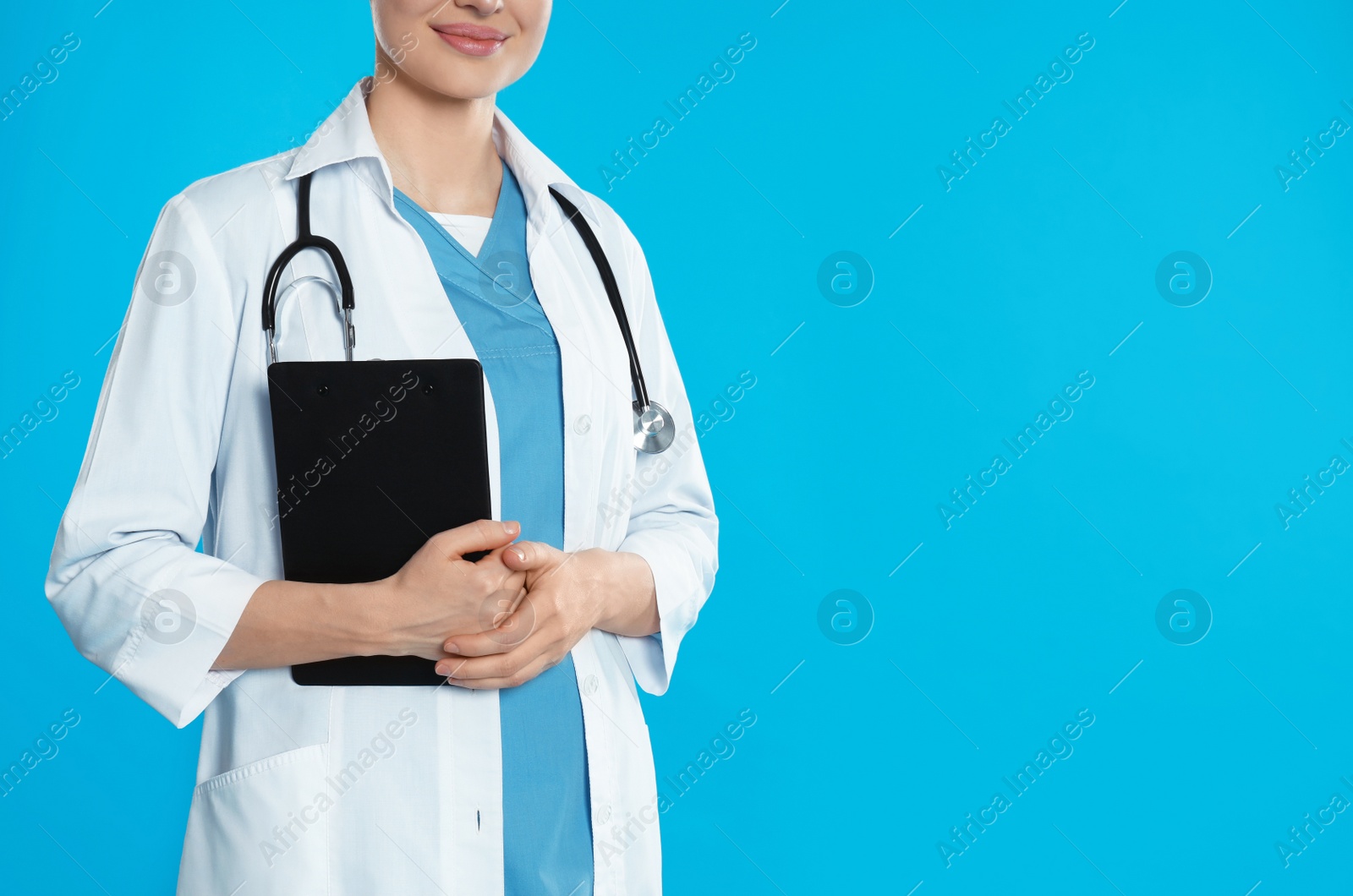 Photo of Doctor with stethoscope and clipboard on blue background, closeup. Space for text