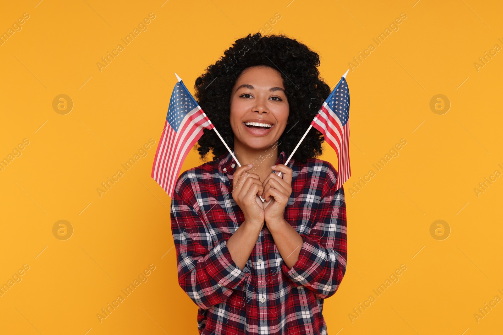 Photo of 4th of July - Independence Day of USA. Happy woman with American flags on yellow background