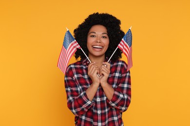 Photo of 4th of July - Independence Day of USA. Happy woman with American flags on yellow background