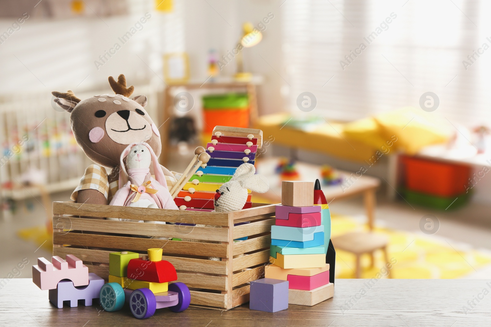 Image of Set of different cute toys on wooden table in children's room