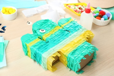 Bright cardboard cactus and materials on wooden table. Pinata diy