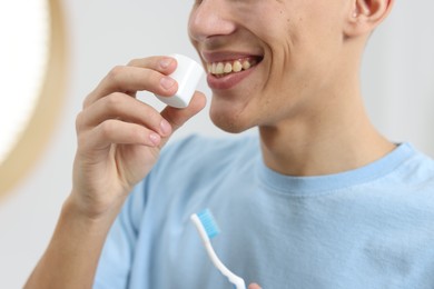 Photo of Young man using mouthwash indoors, closeup view