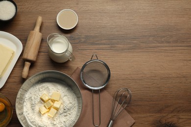 Photo of Flat lay composition with fresh butter among other products on wooden table. Space for text