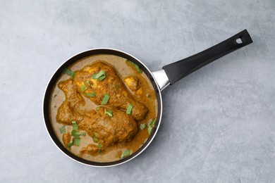 Photo of Delicious chicken with curry sauce on grey table, top view