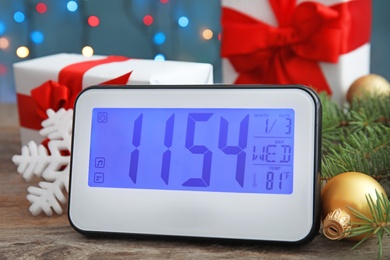 Photo of Electric clock, gifts and festive decor on table. Christmas countdown