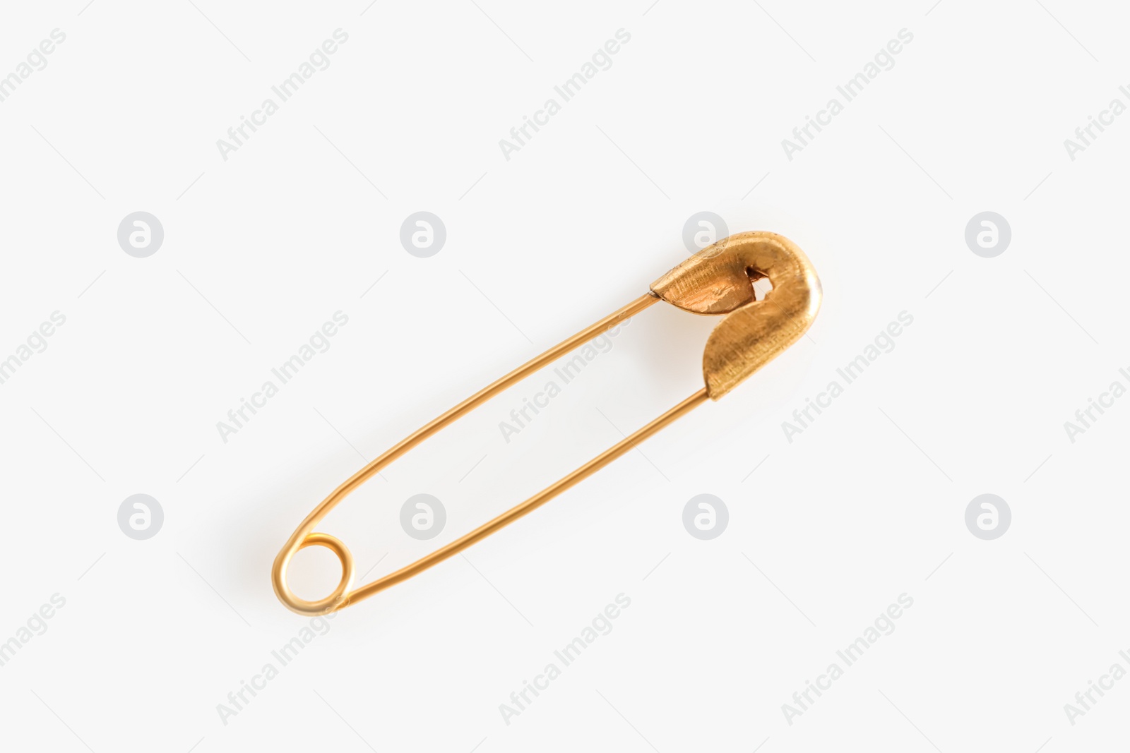 Photo of Golden safety pin on white background, top view