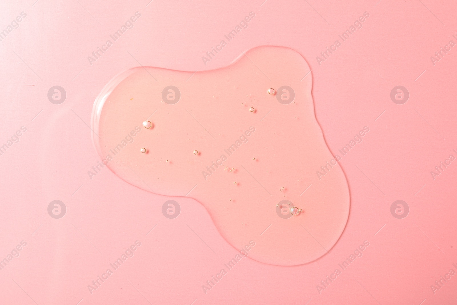 Photo of Drop of hydrophilic oil on pink background, top view