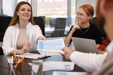 Photo of Team of employees working together in office