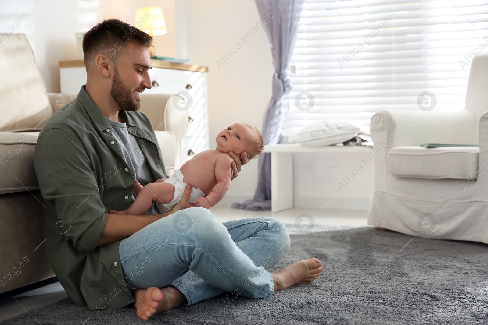 Photo of Father with his newborn son at home