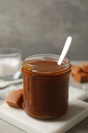 Tasty salted caramel on light grey table, closeup