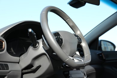 Photo of Black steering wheel and dashboard in modern car