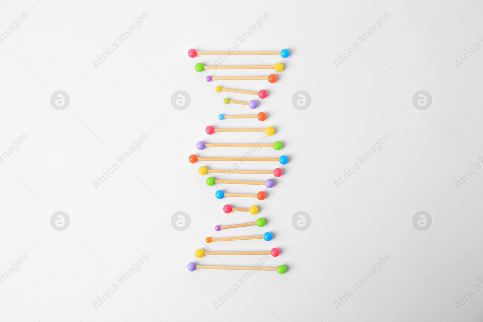 Photo of DNA molecule model made of toothpick and colorful beads on white background, flat lay