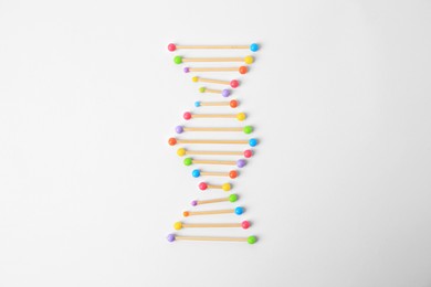 Photo of DNA molecule model madetoothpick and colorful beads on white background, flat lay