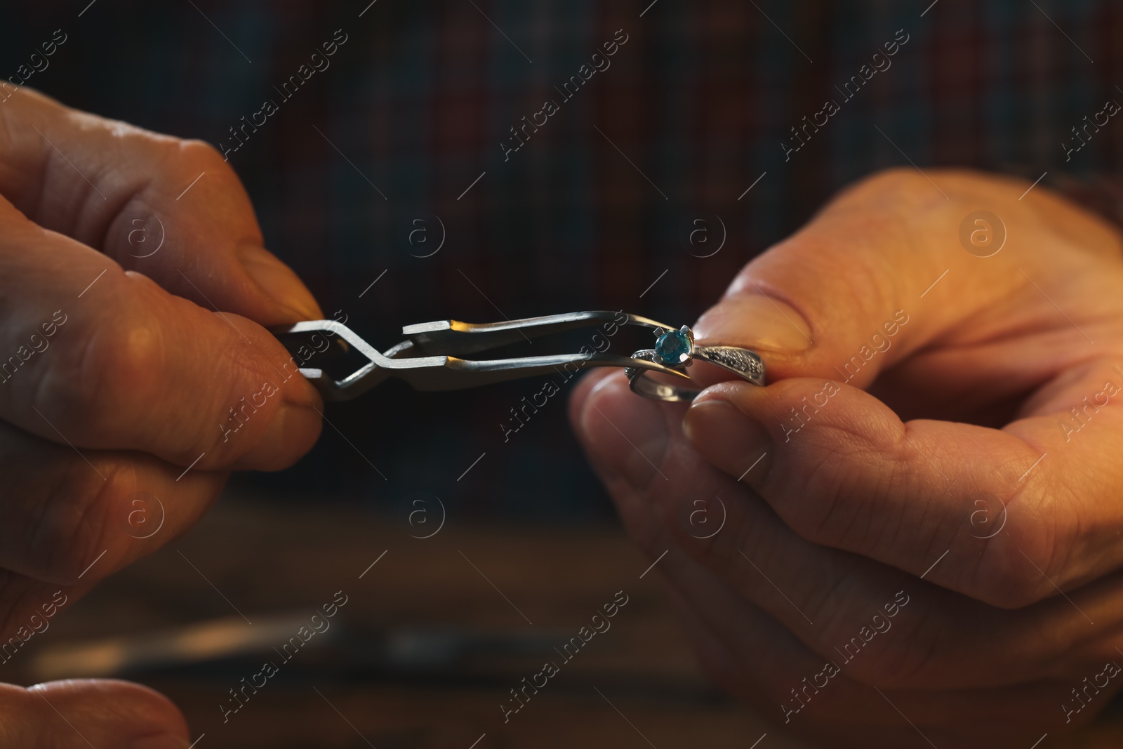 Photo of Professional jeweler working with ring, closeup view