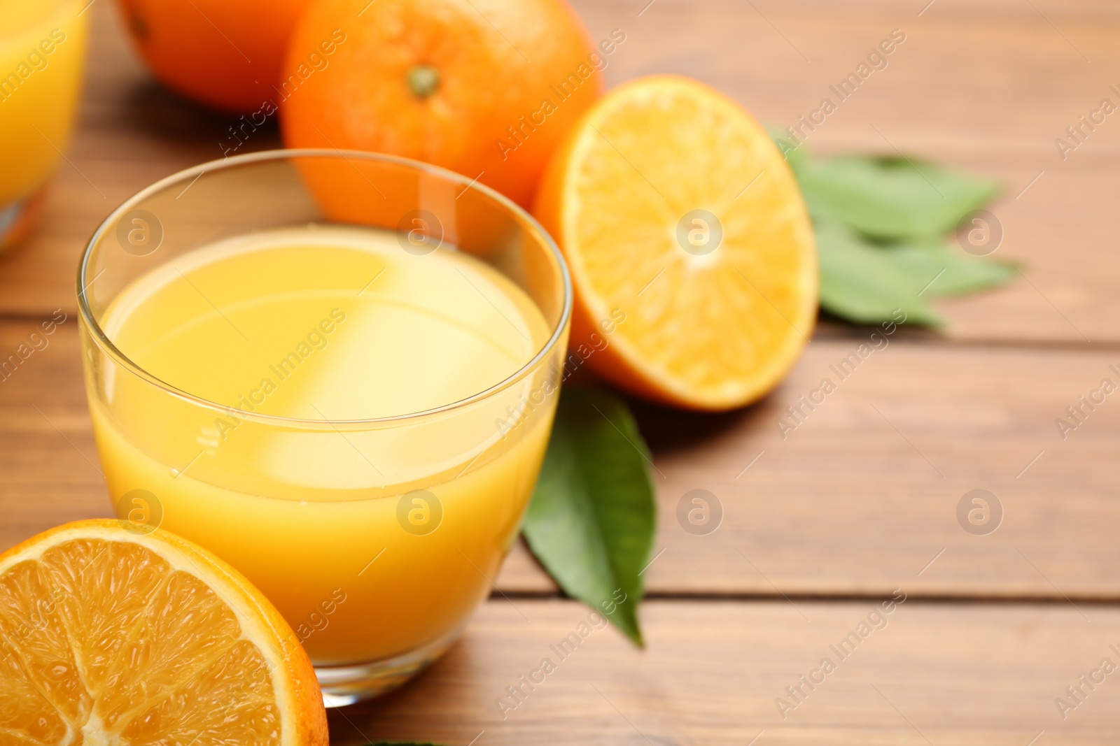 Photo of Delicious orange juice and fresh fruit on wooden table, closeup. Space for text