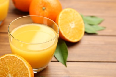 Photo of Delicious orange juice and fresh fruit on wooden table, closeup. Space for text