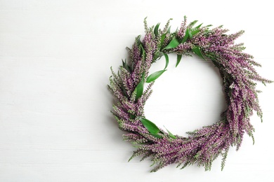 Photo of Beautiful autumnal wreath with heather flowers on white background, top view. Space for text