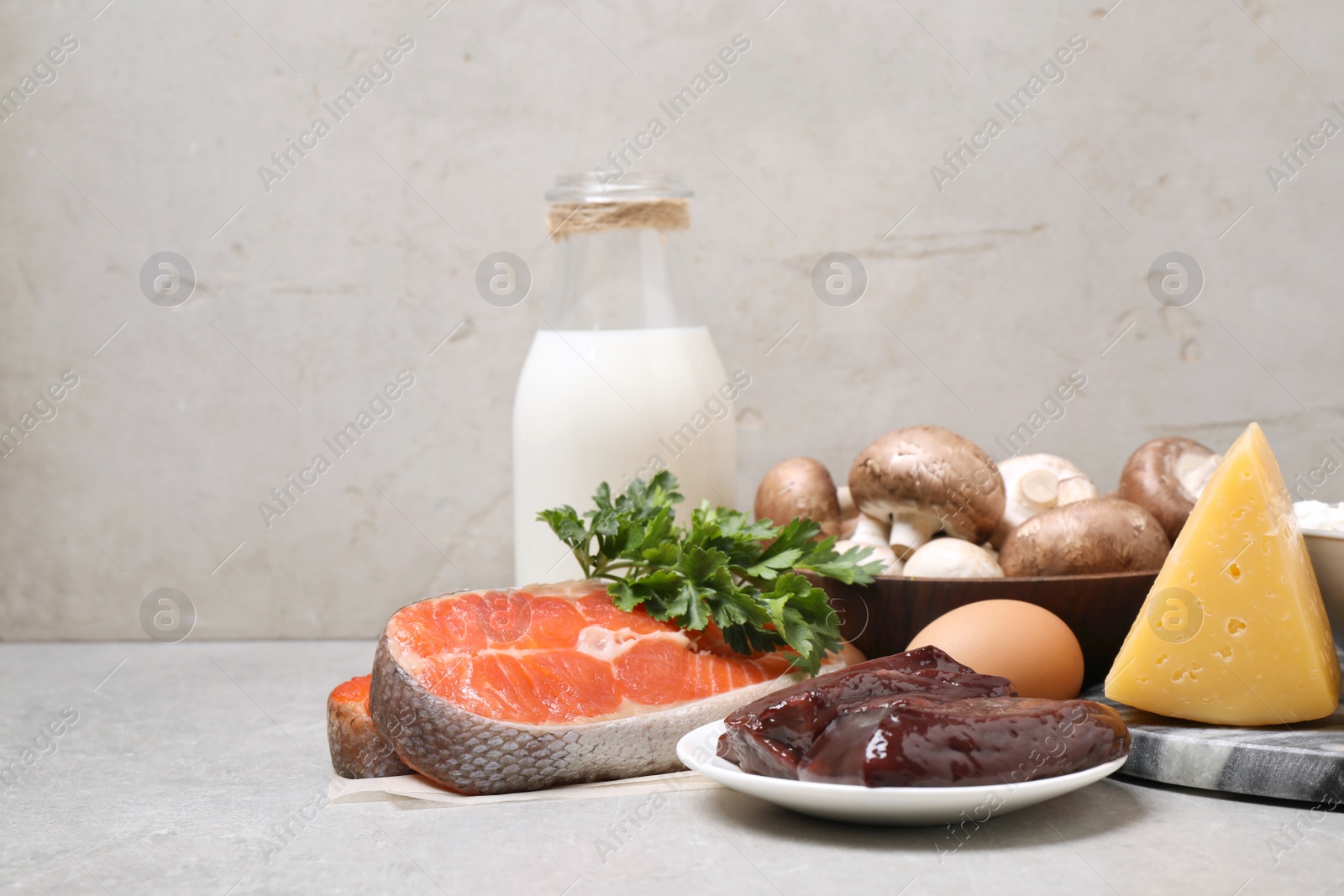 Photo of Fresh products rich in vitamin D on light grey table