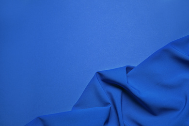 Crumpled fabric and space for text on bright background, top view. Color of the year 2020 (Classic blue)